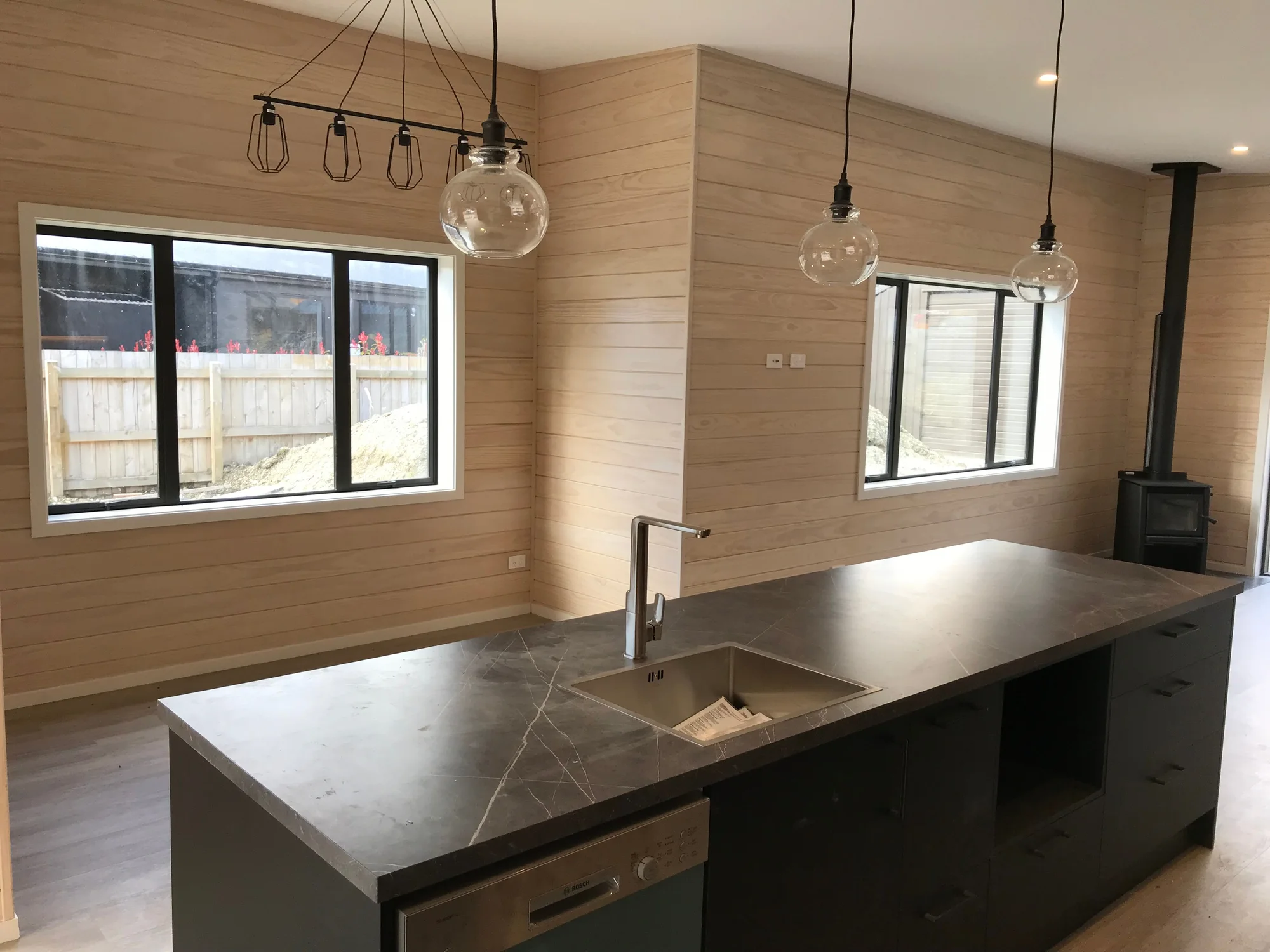Whitewashed timber kitchen and living area finished by Fine Finishes